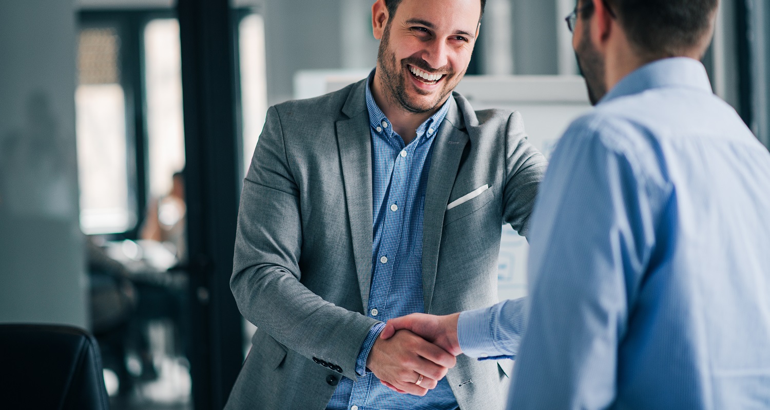 Two Xcelentra clients shaking hands in a meeting